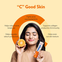 A woman with her eyes closed, holding a product bottle and a half-cut lime, to highlight the skin benefits of Vitamin C.