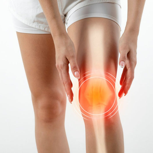 Close-up of person holding painful knee highlighting joint discomfort and inflammation.