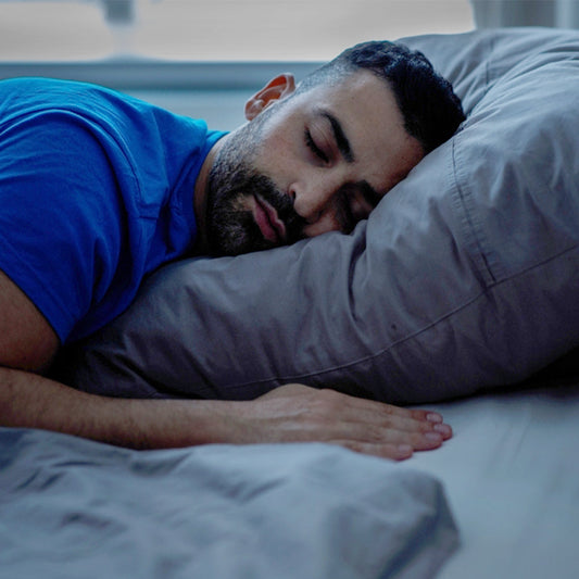 A man in deep, peaceful sleep, illustrating the connection between quality rest and eye health.